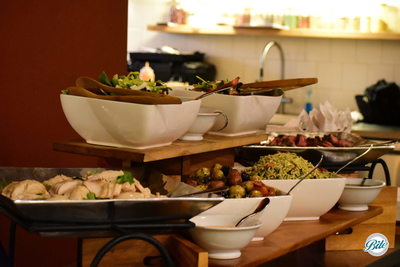 Bite loves buffets displayed on different levels! Visible are slices of a citrus chicken, multiple salads (Spanish Harvest and Strawberry Fields), a pesto orzo salad, provencal potatoes, flank steak