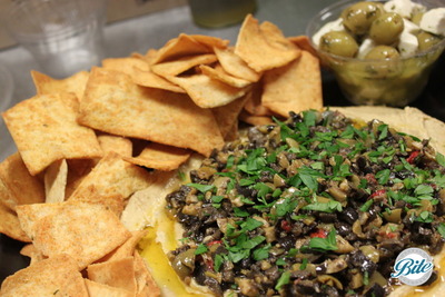 Hummus with olive tapenade, pita chips, and marinated olives with cheese on the side