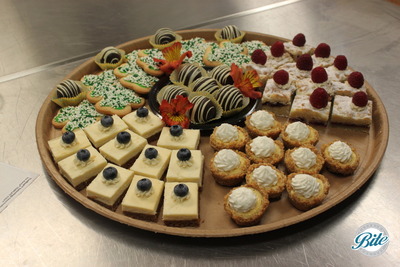 St. Patrick's day themed a la carte dessert assortment with whiskey brownie truffles, shamrock shortbread cookies, raspberry shortbread bites, cheesecake bars and mini citrus tarts