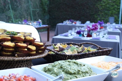 Mexican Taco Station with corn cakes, chips, guacamole, cheese and guacamole, guest reception seating shown in the distance