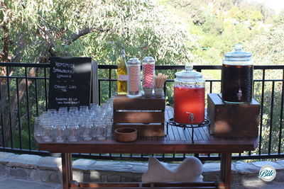 Rustic BBQ beverage station with homemade lemonade in beverage dispensers on wooden crates with chalkboard signage