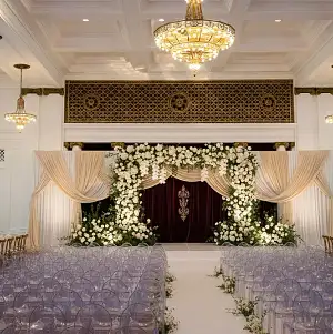 Indoor Wedding Setup with Floral Arch and Drape in Grand Ballroom