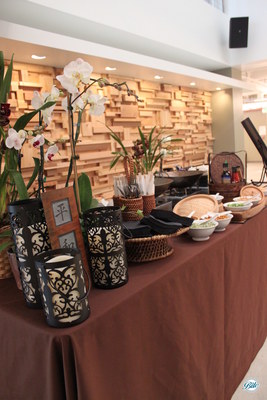 Wok station with noodles and accompaniments displayed with orchids and asian inspired decor